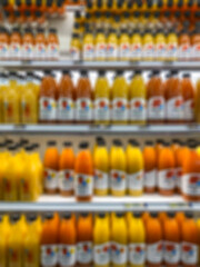 blurred background with juice bottles on shelves in a supermarket
