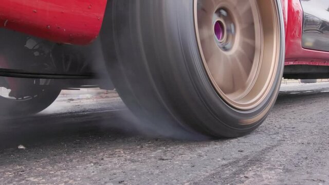 Drag racing car burning tire at starting line in race  track