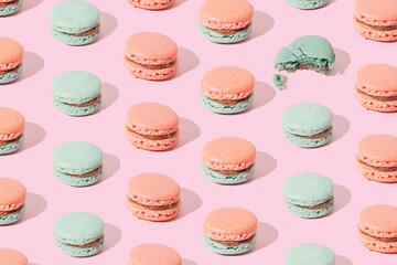 Pink and light green macarons on green background. Pattern.