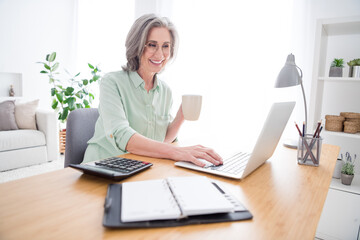 Profile photo of cheerful candid person hand hold tea mug beaming smile look laptop typing email indoors