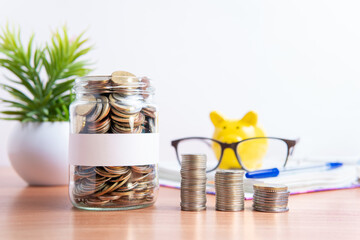The coins are stored in a glass jar to accumulate finances.