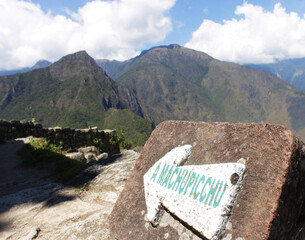 Arrow on the way to machu picchu, means to the old peak, with mountains in the background 
