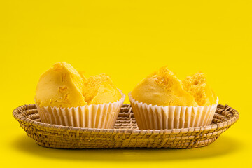 Yellow collection. Side view of egg yolk threads yellow cotton candy cake in bamboo tray on yellow background.