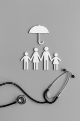 Medical care concept. Family figure with stethoscope, top view