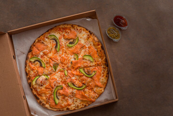 Pizza with salmon and avocado in box