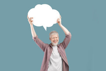 Excited albino gut holding empty speech bubble above his head over turquoise studio background
