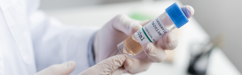 Obraz premium Cropped view of vaccine in hands of doctor in latex gloves, banner