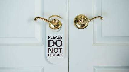 White door of a hotel room with a sign Do not disturb