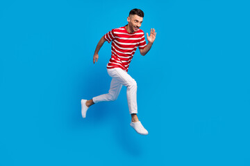 Fototapeta na wymiar Full size profile side photo of happy man hurry sale jump run isolated on pastel blue color background
