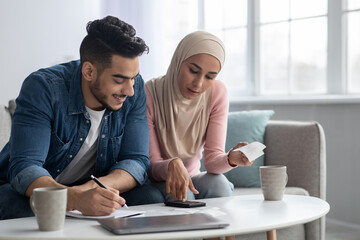 Positive muslim family counting their spendings, feeling wealthy