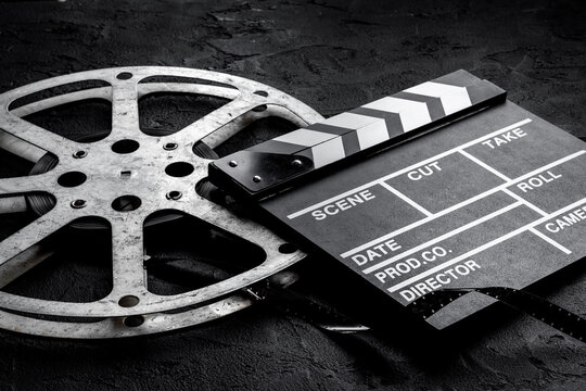 Cinema background with movie clapperboard and film reel