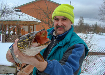fisherman with pike in his hands