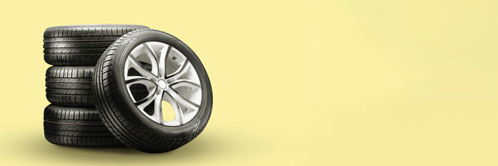 summer tires and wheels-stack on yellow background, new wheels long blank layout copyspace