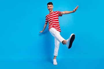 Fototapeta na wymiar Low angle view full size photo of cheerful young man dance good mood isolated on blue color background