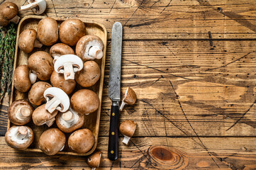 Cut Raw mushrooms brown champignon. wooden background. Top view. Copy space