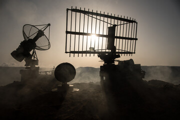 Space radar antenna on sunset. Silhouettes of satellite dishes or radio antennas against night sky....