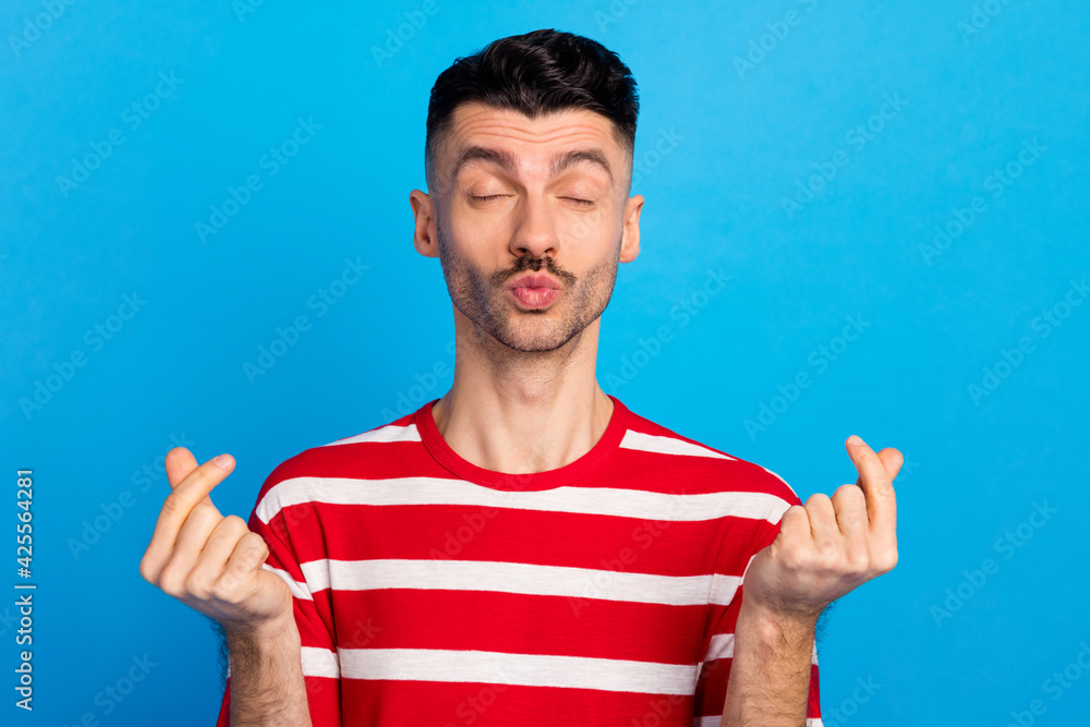 Poster Photo of flirty happy young brunette man make fingers hearts send air kiss isolated on blue color background