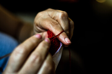 close up of a person holding a needle