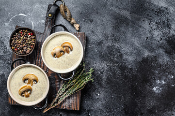 Fototapeta na wymiar Champignon Mushroom cream soup with herbs in a bowl. Black background. Top view. Copy space