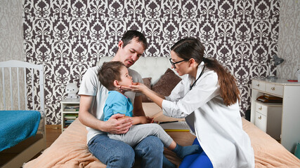 Obraz premium The doctor examines a sick child at home