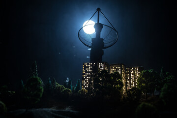 Silhouettes of satellite dishes or radio antennas against night sky. Space observatory or Air defence radar over dramatic night sky. Creative artwork decoration. Selective focus