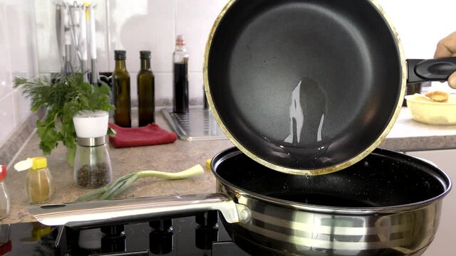 The cook pours oil from the pan into the cooking tray.
The high-quality Teflon coating of the frying pan can be seen in close-up.