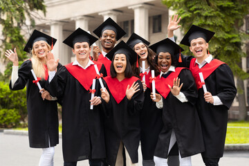 Diverse International Students With Diplomas Celebrating Graduation, waving at camera