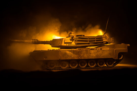 War Concept. Armored vehicle silhouette fighting scene on war foggy sky background at night. American tank ready to fight.