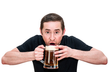 A man in a black T-shirt drinks beer while holding a glass with both hands. Isolated white background.