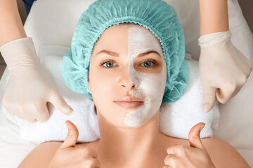 A beautician applies a mask to the face in a beauty salon. The concept of facial hygiene, cosmetic...