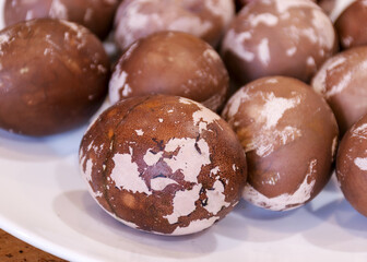 Easter eggs on a plate, European Easter with traditional decoration eggs, easter eggs decorated with natural fresh leaves and boiled in onions peels and blueberry berries