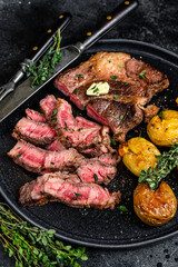Cut Grilled rib eye beef meat steak with potato. Black background. Top view
