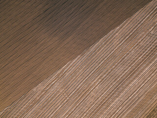 Fototapeta premium Brown plowed field. Brown background on the field aerial view. Earth top view.