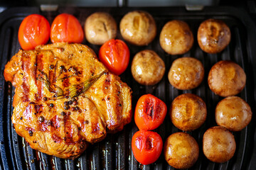 Grilled steak with vegetables and herbs. Juicy steak is grilled with tomatoes and mushrooms. Grilled vegetables with meat. Pork with spices is fried. Cooking meat. Grilled veal steak with vegetables.
