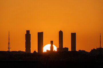 Vista del skyline de Madrid con sus cinco torres con el sol poniéndose al atardecer por detrás de...