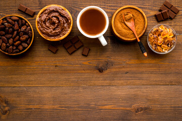Cocoa beans and powder with hot chocolate in white cup. Top view, flat lay
