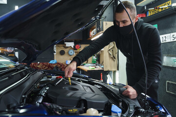 Obraz na płótnie Canvas Man doing car maintenance at inspection station