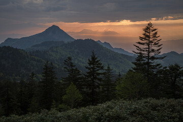 高原の向こうで雲間から夕日が顔を出そうとしている