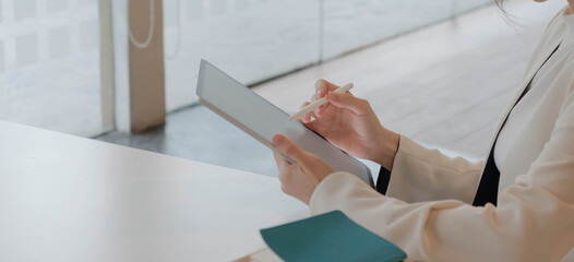Business woman working with stylus pen on pro digital tablet with graphics design diagram