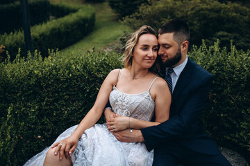 The newlyweds are walking in nature in the park on a summer day.