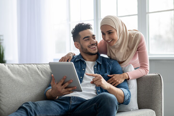 Young muslim couple using mobile app on digital tablet