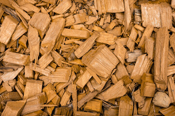 Fototapeta premium A lot of orange shavings, wood chips, sawdust, pieces of wood material make decoration on the surface. orange designed texture, close-up.