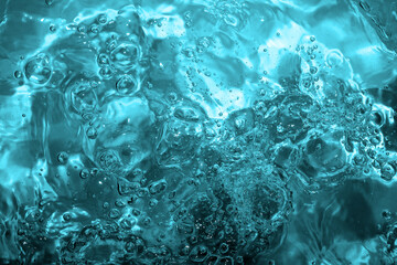 Pool, hot tub water background. Ripples on blue transparent water in swimming pool with light...