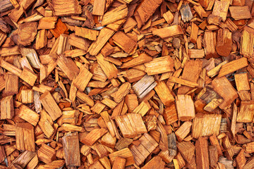 orange wooden splinters close-up. Decorative wood chips texture. Natural material pattern of red wooden pieces of tree bark. Full filled frame picture above view.