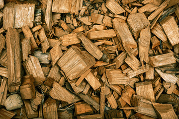 Decoration of flower beds with decorative wood chips and plants. Landscaping in the city park. Colored yellow wood chips. Shrubs with mulch