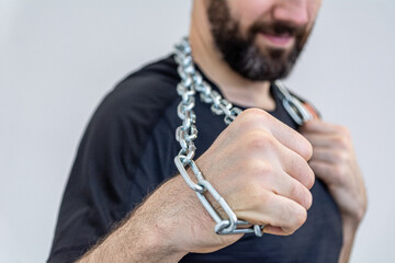 the young man holds an iron chain in his fist.