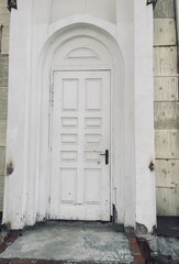 Old decayed white wooden closed door exterior	