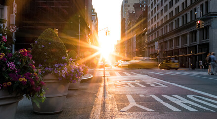 New York City busy street scene with the sun setting behind the buildings on Fifth Avenue in...