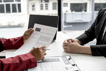 The manager is interviewing job applicants and reading the candidate's personal information on the resume. The idea of recruiting to recruit people to work in the missing position.