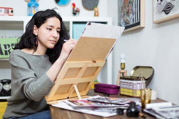 Young woman artist concentrating on the project she is working on. Home entertainment concept.